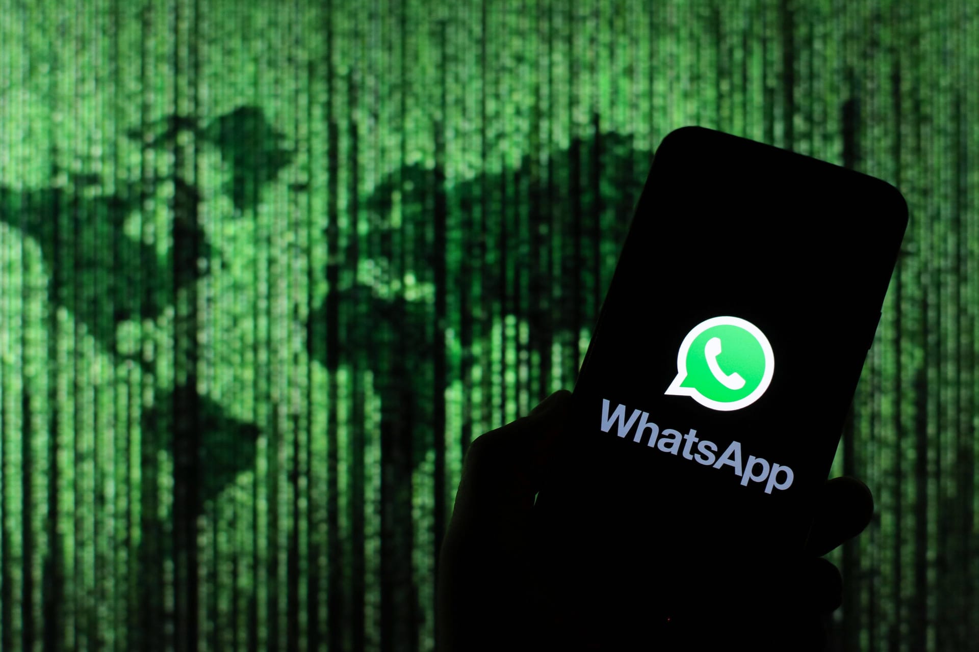 Das Logo von WhatsApp auf einem Smartphone: Back-ups von WhatsApp-Chats soll man bald verschlüsseln können.