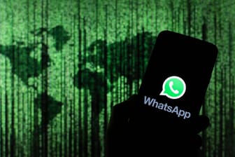 Das Logo von WhatsApp auf einem Smartphone: Back-ups von WhatsApp-Chats soll man bald verschlüsseln können.