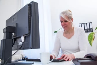 Eine Frau am Computer: Immer anspruchsvollere Programme können den Rechner in die Knie zwingen, wenn man nichts unternimmt.