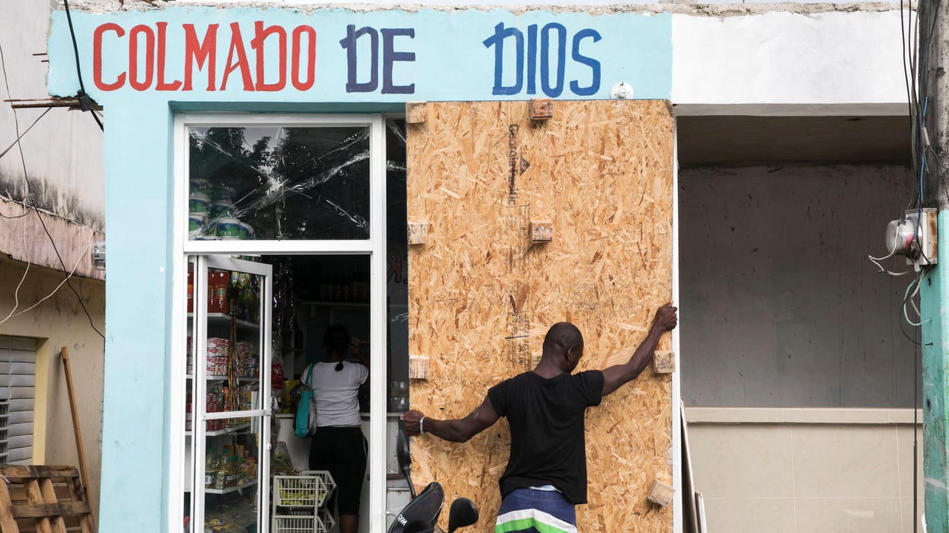 In der Dominikanischen Republik sichern Menschen ihr Hab und Gut vor drohenden Sturmschäden - hier ein Geschäft in Las Terrenas mit Sperrholzplatten.