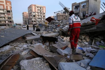 Ein Rettungssanitäter sucht mit einem Spürhund nach Überlebenden: Die Zahl der Toten und Verletzten des Erdbebens in Iran und Irak steigt weiter an.