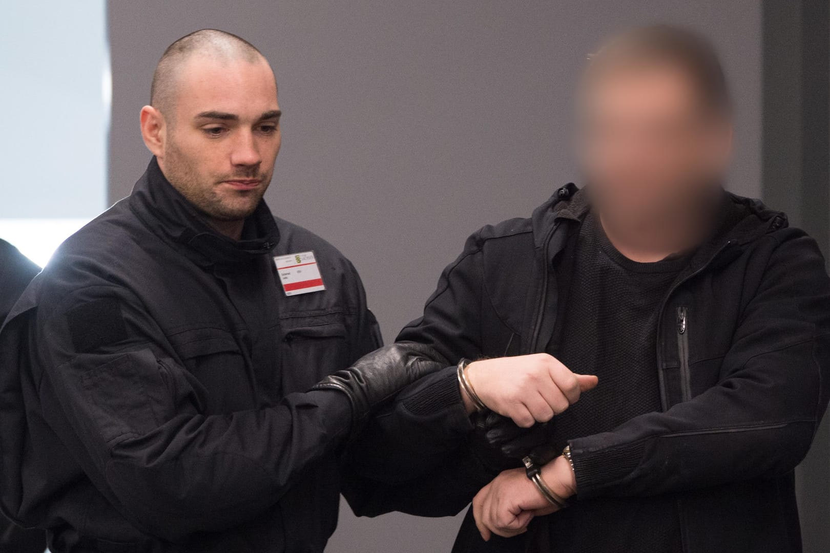 Der angeklagte Rico K. wird von einem Polizisten in den Gerichtssaal geführt: Den Rechtsextremisten der "Gruppe Freital" wird versuchter Mord vorgeworfen.