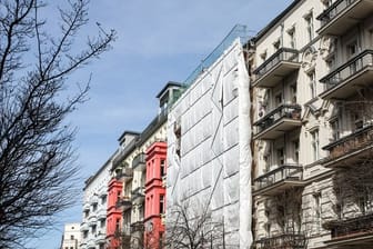 Eine Bauplane verdeckt ein Haus in der Immanuelkirchstraße im Berliner Stadtteil Prenzlauer Berg.