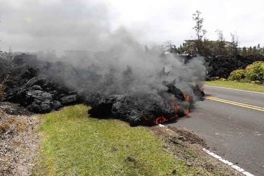 Nach dem Ausbruch des Kilauea auf Hawaii walzt sich ein Lavastrom über eine Straße.