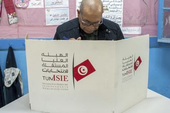 Ein Mann bereitet sich vor, seine Stimme in einem Wahllokal abzugeben. Nach ersten Prognosen liegen die islamisch-konservative Partei Ennahda (Wiedergeburt) vorn.