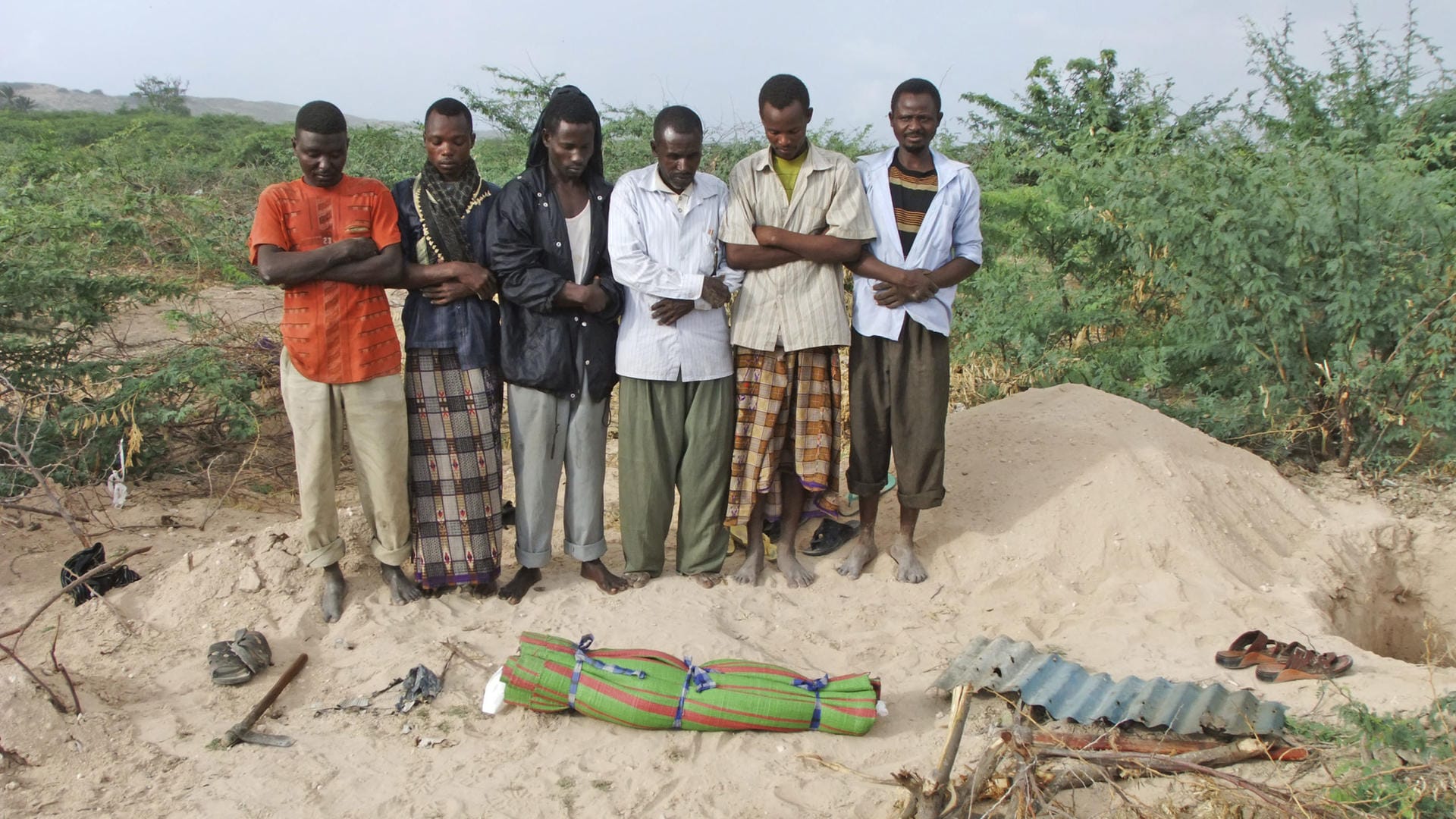 Somali men from southern Somalia offer funeral prayers for a dead child in... Somali men from southern Somalia offer funeral prayers for a dead child in...