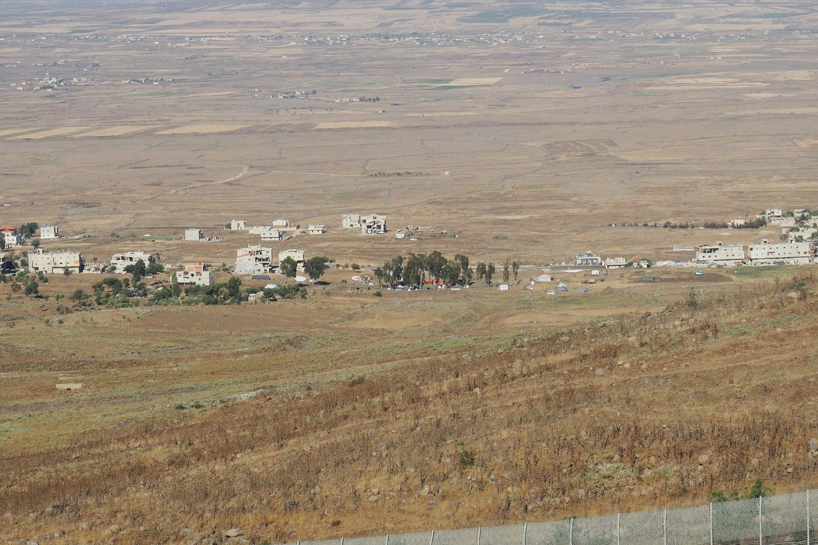 Blick von einem Hügel in Israel über den Grenzzaun nach Syrien: Nach massiven Angriffen im Süden Syriens sind vermutlich mehr als 300 000 Menschen auf der Flucht.