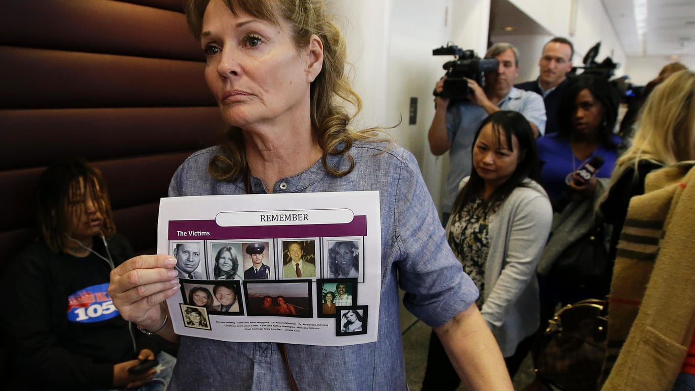 Eine Frau hält nach einer Anhörung eines Ex-Polizisten die Fotos von Mordopfern: Nach einer Mord- und Vergewaltigungsserie in den 70er und 80er Jahren in Kalifornien werden einem Ex-Polizisten in dem US-Westküstenstaat nun 13 Morde zur Last gelegt.