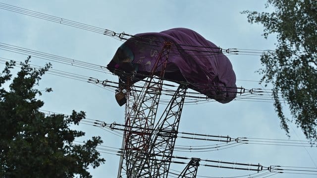 Höhenretter der Feuerwehr klettern zu dem Korb eines Heißluftballons der sich in einer Hochspannungsleitung verfangen hat. Höhenretter der Feuerwehr klettern zu dem Korb eines Heißluftballons der sich in einer Hochspannungsleitung verfangen hat.