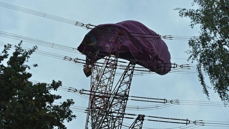Höhenretter der Feuerwehr klettern zu dem Korb eines Heißluftballons der sich in einer Hochspannungsleitung verfangen hat.
