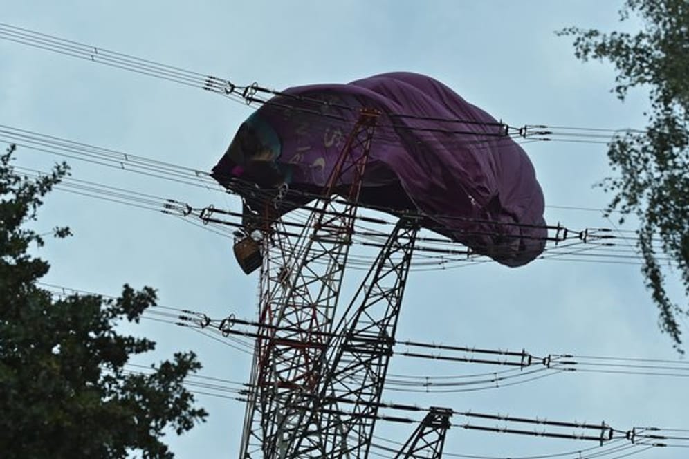 Höhenretter der Feuerwehr klettern zu dem Korb eines Heißluftballons der sich in einer Hochspannungsleitung verfangen hat.