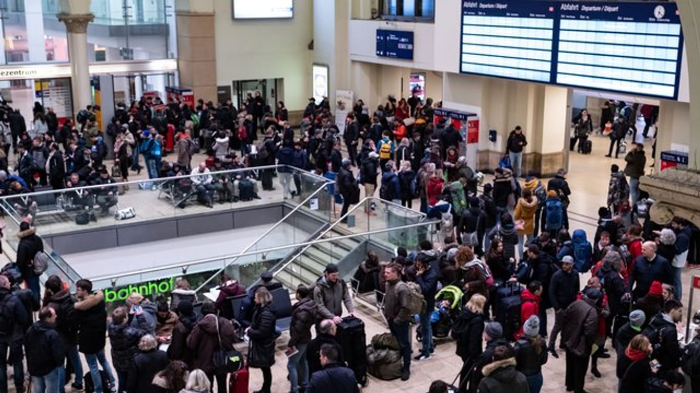 Reisende warten auf dem Hauptbahnhof in Hannover, dass der Zugverkehr wieder anläuft.