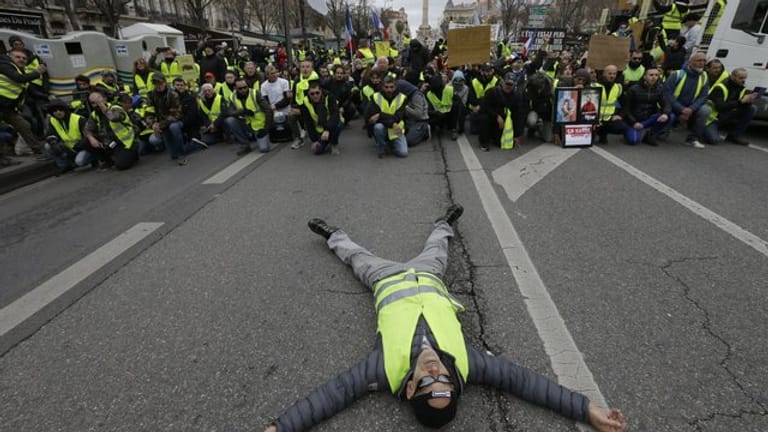 Ein Demonstrant liegt bei einem Protest der "Gelbwesten" in Marseille auf der Straße.