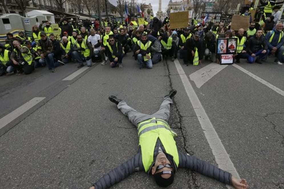 Ein Demonstrant liegt bei einem Protest der "Gelbwesten" in Marseille auf der Straße.