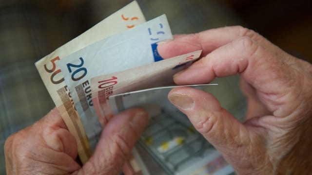 Eine ältere Frau zählt Geld.