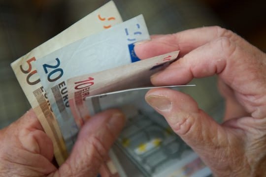 Eine ältere Frau zählt Geld.