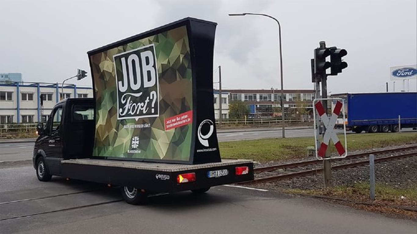 Ein Lieferwagen mit der Bundeswehr-Anzeige fährt am Ford-Werk in Köln vorbei.