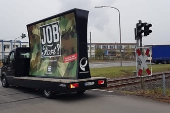 Ein Lieferwagen mit der Bundeswehr-Anzeige fährt am Ford-Werk in Köln vorbei.
