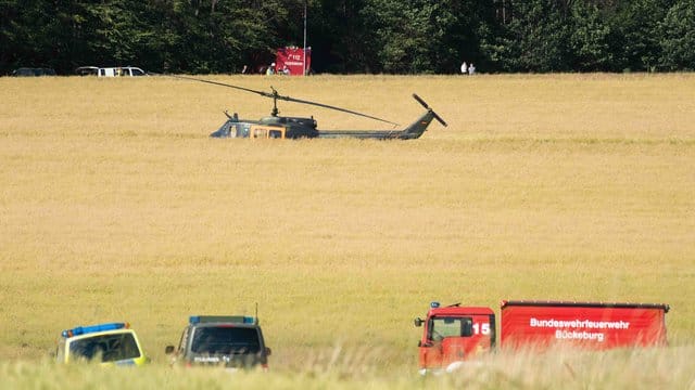 Einsatzfahrzeuge und ein Hubschrauber der Bundeswehr nahe der Absturzstelle.