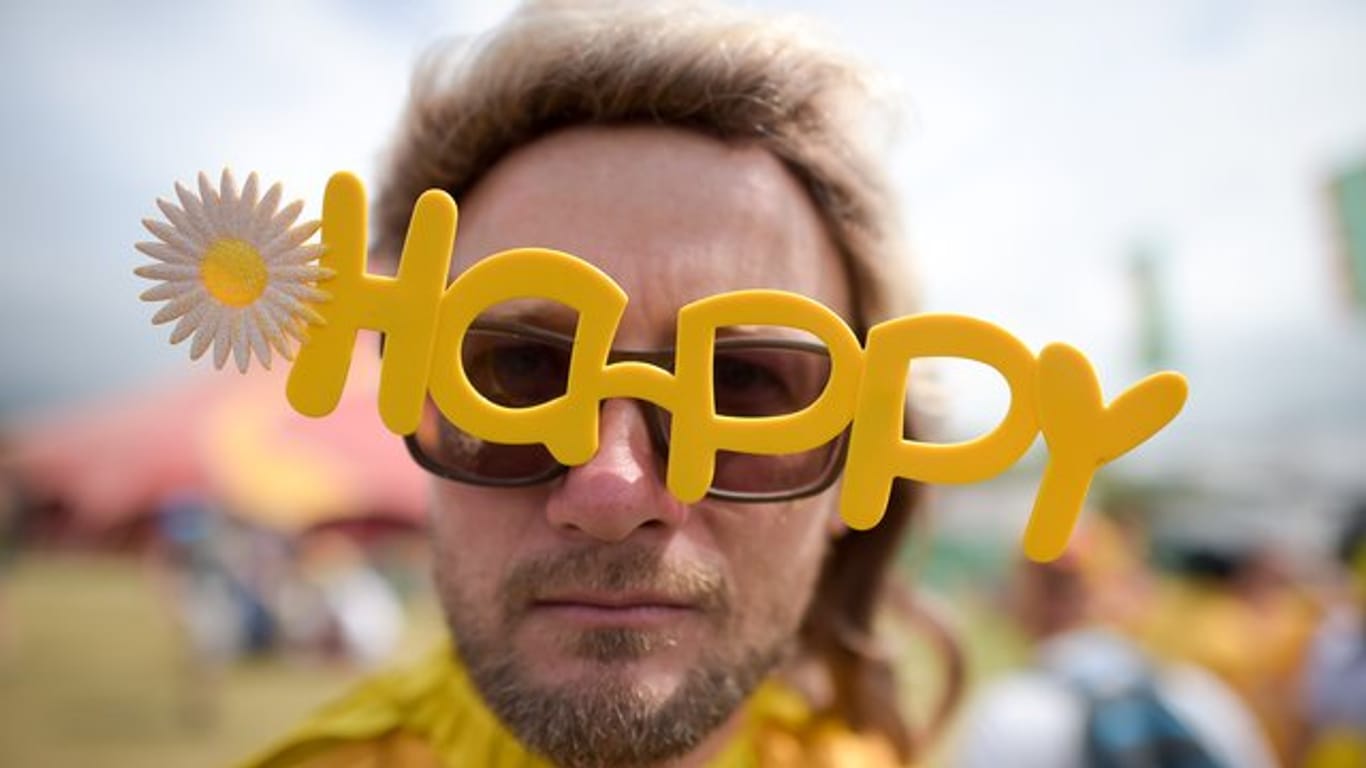 Ein Besucher eines Festivals in Großbritannien mit einer "Happy"-Brille.