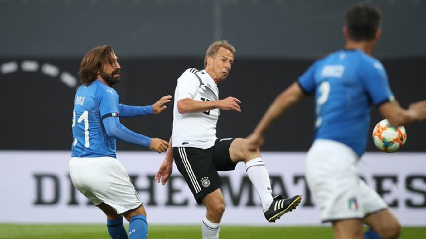 Jürgen Klinsmann (M) trift zum 2:0 für die DFB-All-Star, Italiens Andrea Pirlo (l) kommt zu spät.