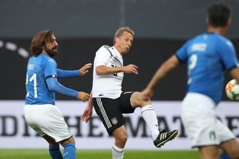 Jürgen Klinsmann (M) trift zum 2:0 für die DFB-All-Star, Italiens Andrea Pirlo (l) kommt zu spät.