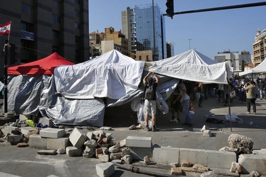Regierungskritische Demonstranten bauen ihre Zelte auf einer Hauptstraße in der libanesischen Hauptstadt ab.