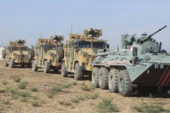Türkische und russische Soldaten in Panzer und Militärfahrzeugen patroullieren an der türkisch-syrischen Grenze.