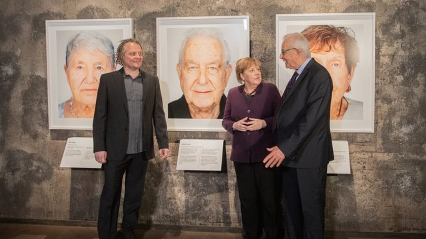 Der Künstler Martin Schoeller (l), der Holocaust-Überlebende Naftali Fürst und Bundeskanzlerin Angela Merkel (CDU) bei der Eröffnung der Ausstellung "Survivors - Faces of Life after the Holocaust" in Essen.
