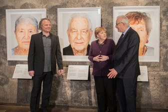 Der Künstler Martin Schoeller (l), der Holocaust-Überlebende Naftali Fürst und Bundeskanzlerin Angela Merkel (CDU) bei der Eröffnung der Ausstellung "Survivors - Faces of Life after the Holocaust" in Essen.