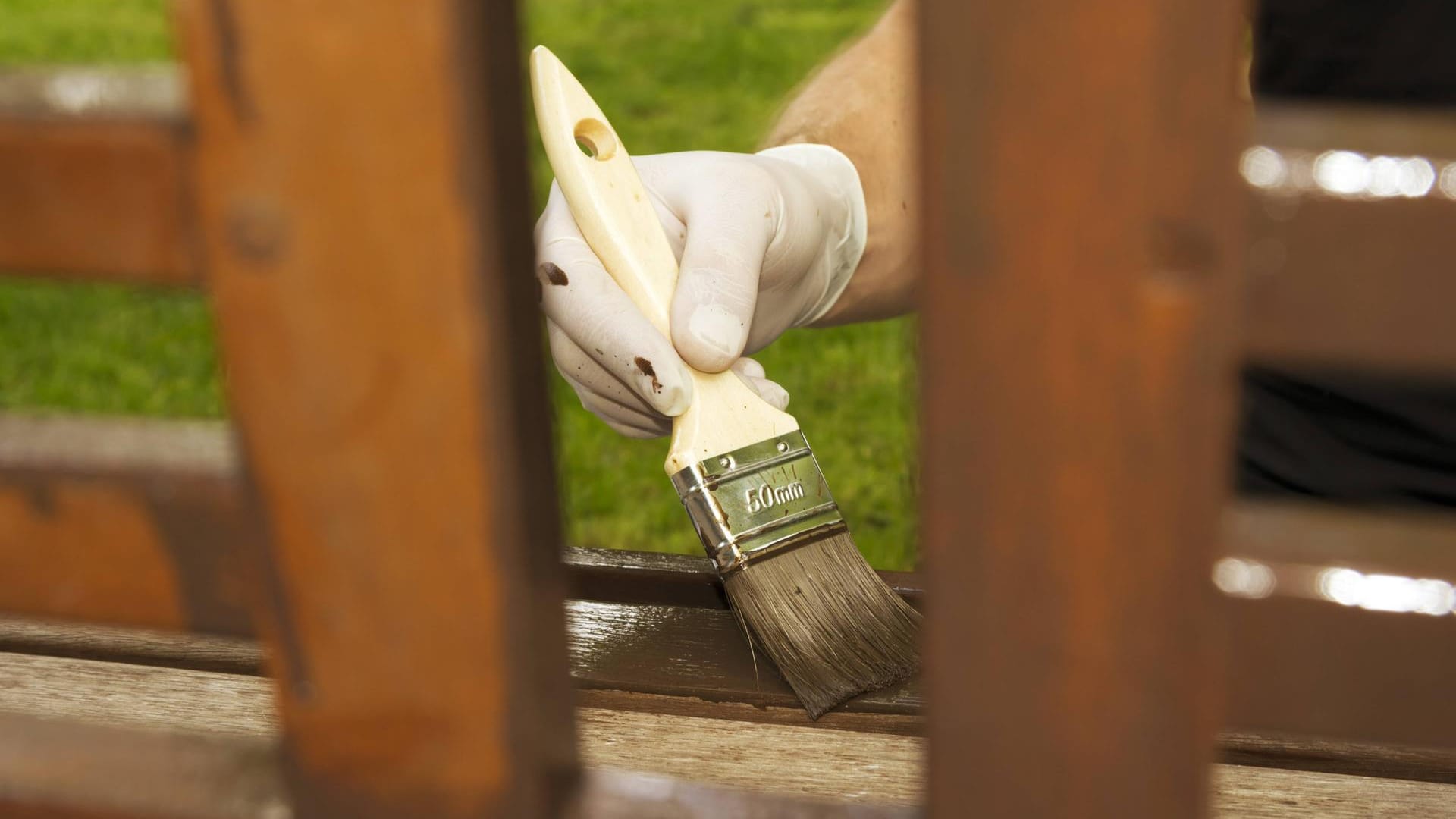 Holz lasieren: Der häufigste Fehler ist, dass mit dem Pinsel zu viel Flüssigkeit aufgetragen wird.