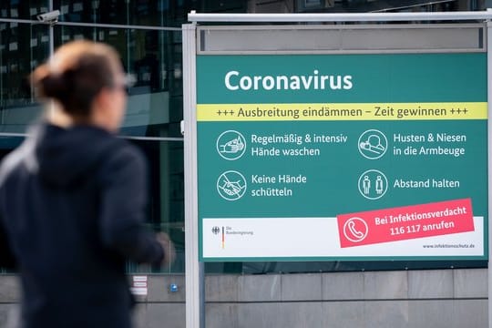 Ein Plakat informiert vor dem Bundespresseamt über Schutzmaßnahmen zum Coronavirus.