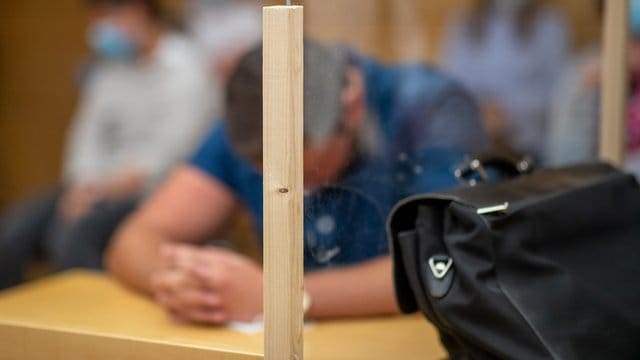Ein angeklagter Polizeischüler sitzt zu Prozessbeginn im Sitzungssaal im Amtsgericht.