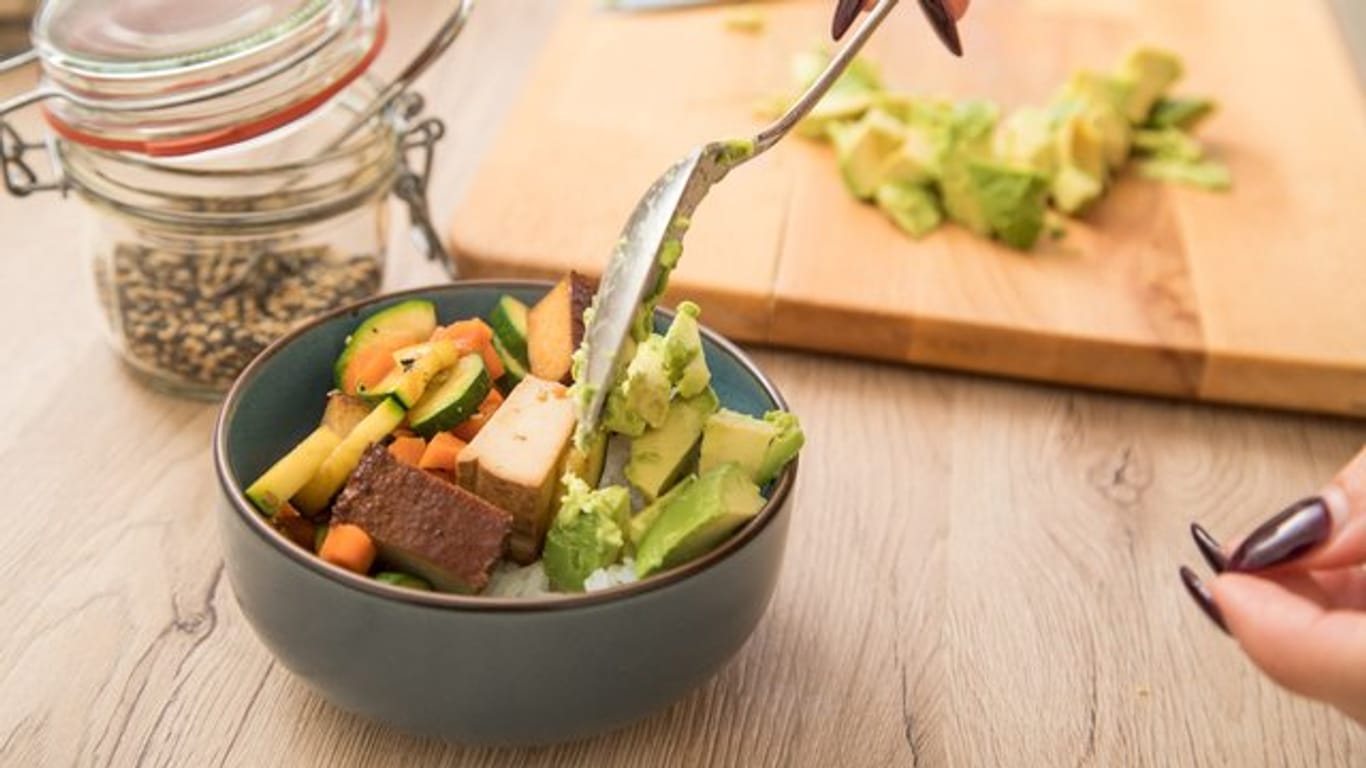 Avocadowürfel mit Reis, Gemüse und Tofu sind eine gesunde Alternative.