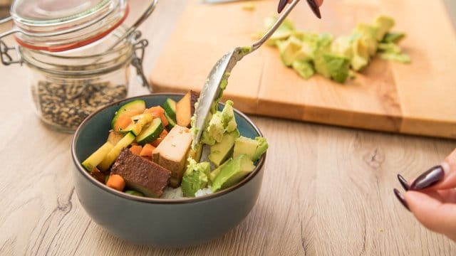 Avocadowürfel mit Reis, Gemüse und Tofu sind eine gesunde Alternative.