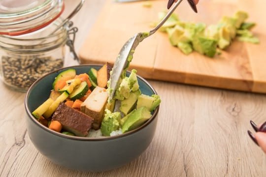 Avocadowürfel mit Reis, Gemüse und Tofu sind eine gesunde Alternative.