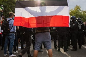 Ein Mann hält eine Reichsflagge bei einem Protest gegen die Corona-Maßnahmen vor der russischen Botschaft.