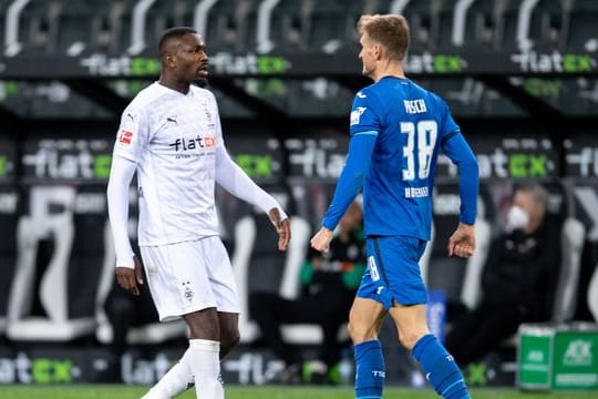 Gladbachs Marcus Thuram (l) hatte Hoffenheims Stefan Posch ins Gesicht gespuckt.
