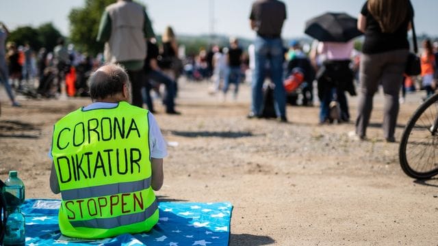 Ein Teilnehmer trägt auf dem Cannstatter Wasen bei einer Kundgebung der Initiative "Querdenken 711" eine Warnweste mit der Aufschrift "Corona Diktatur stoppen". Ein Teilnehmer trägt auf dem Cannstatter Wasen bei einer Kundgebung der Initiative "Querdenken 711" eine Warnweste mit der Aufschrift "Corona Diktatur stoppen".