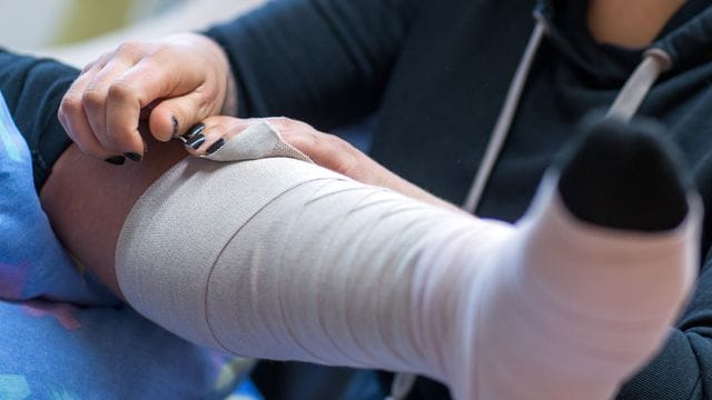 Eine Pflegeschülerin übt das Anlegen eines Thrombose-Verbandes. Eine Pflegeschülerin übt das Anlegen eines Thrombose-Verbandes.