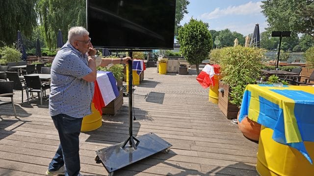 Der Betreiber des Biergartens am Aachener Weiher stellt einen Fernsehbildschirm für die EM auf. Der Betreiber des Biergartens am Aachener Weiher stellt einen Fernsehbildschirm für die EM auf.