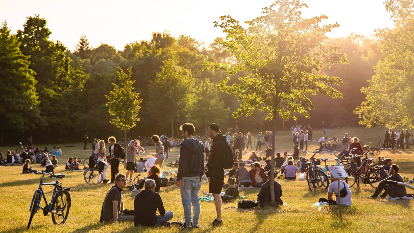 Menschen genießen die Abendsonne in einem Park (Symbolbild): Draußen können sich wieder deutlich mehr Personen treffen.