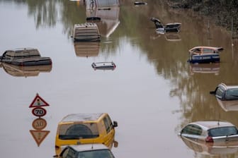 Autos stehen auf der überfluteten Bundesstraße 265 in Erftstadt im Wasser.