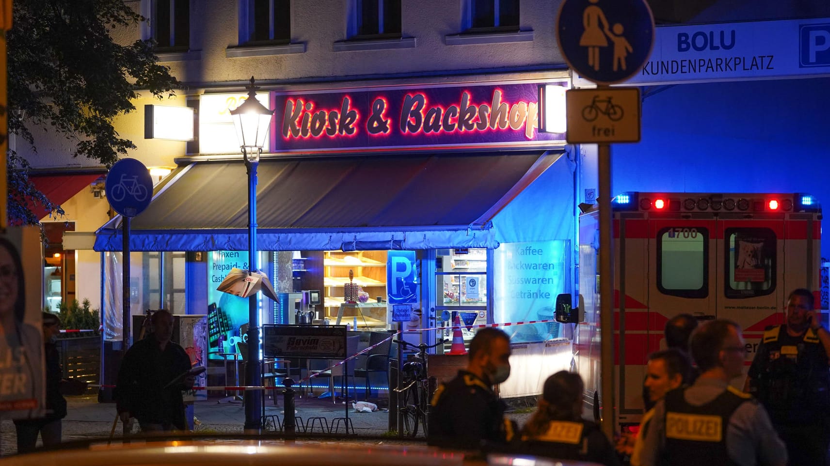 Einsatzkräfte der Polizei stehen vor einem Kiosk in der Reinickendorfer Straße: Dort wurde ein Mann niedergeschossen.