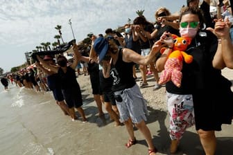 Demonstranten und Demonstrantinnen bilden eine mehr als 73 Kilometer lange Menschenkette am Ufer des Mar Menor.