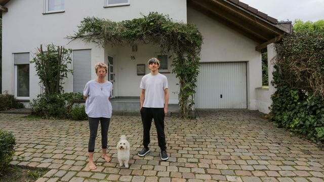 Anja Kassenpecher und ihr Sohn Dennis stehen vor ihrer vorübergehenden Bleibe im nordrhein-westfälischen Kuckum.