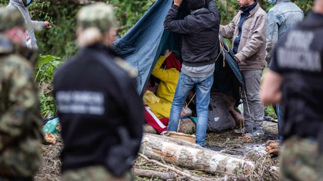 Afghanische Flüchtlinge bauen in einem behelfsmäßigen Lager an der Grenze zwischen Polen und Belarus Zelte auf.