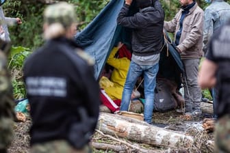Afghanische Flüchtlinge bauen in einem behelfsmäßigen Lager an der Grenze zwischen Polen und Belarus Zelte auf.