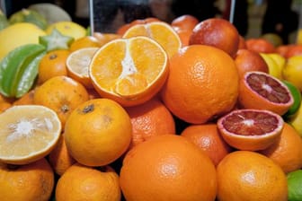 Orangen liegen mit anderen Zitrusfrüchten in Körben auf der Messe "Grüne Woche".