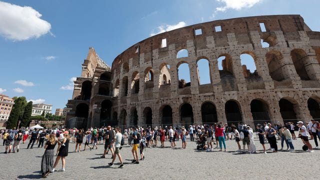 Touristen warten in einer Schlange, um das Kolosseum zu betreten.